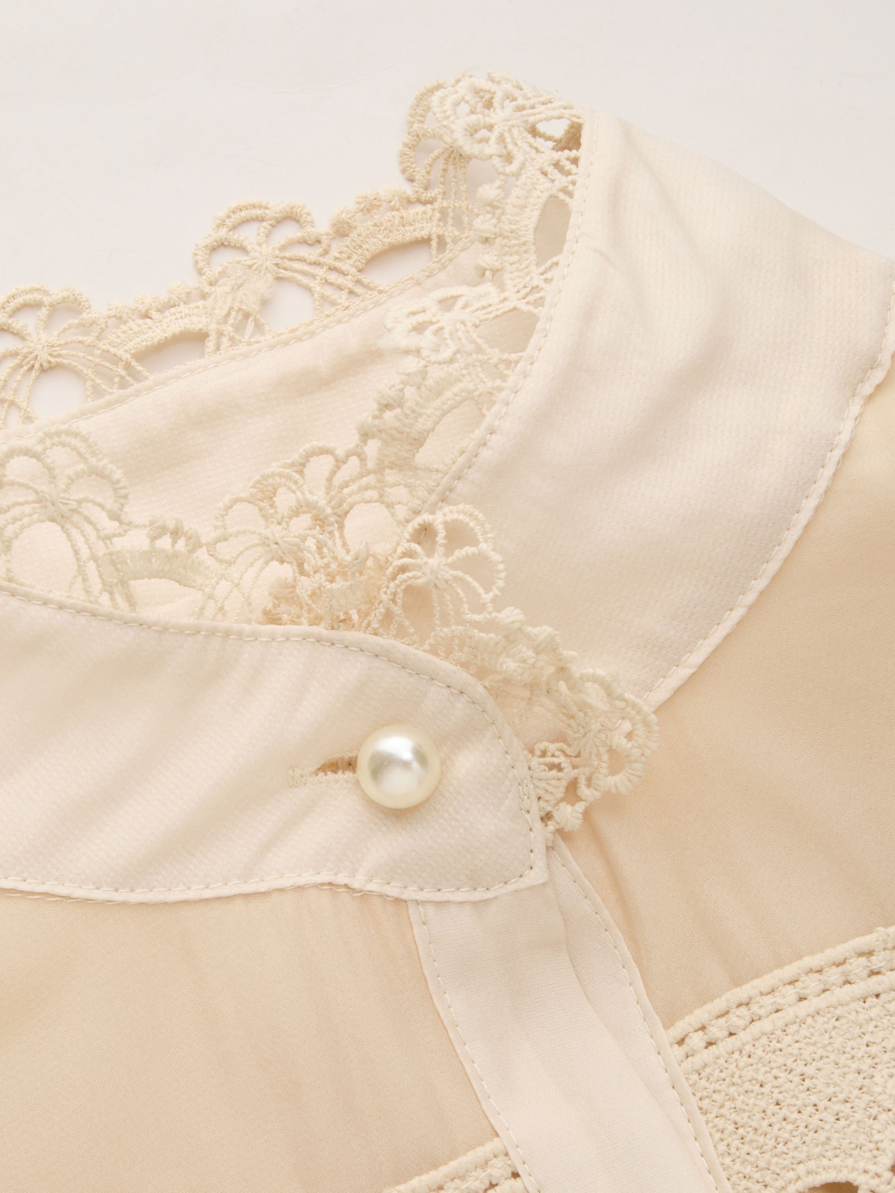 Vestido largo de gasa con cuello alto, guipur y botones de perla